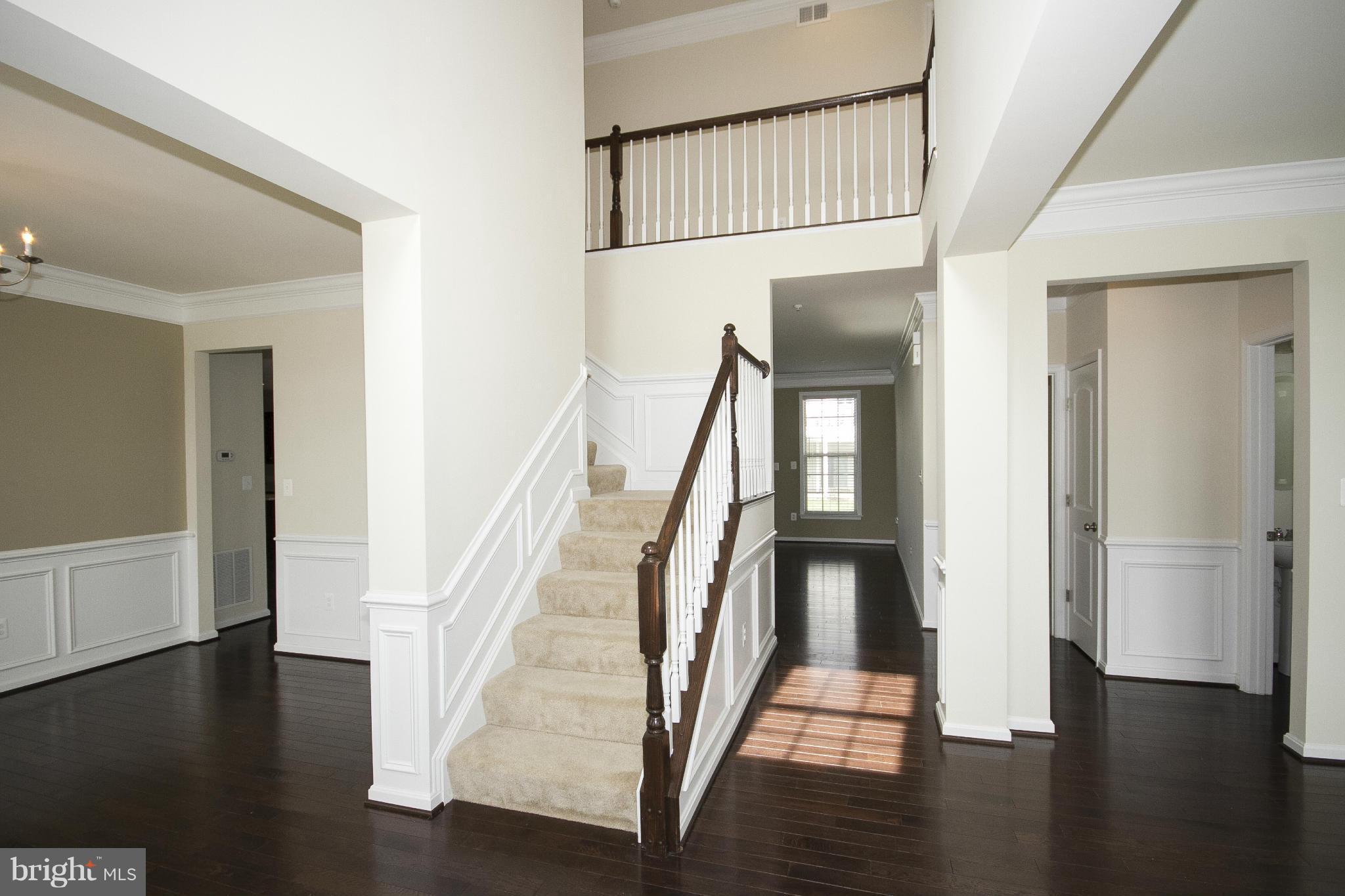 4310 Stoss Road Perry Hall, MD 21128 - Photo 2 of 22 a view of staircase with lots of frames on wall and wooden floor