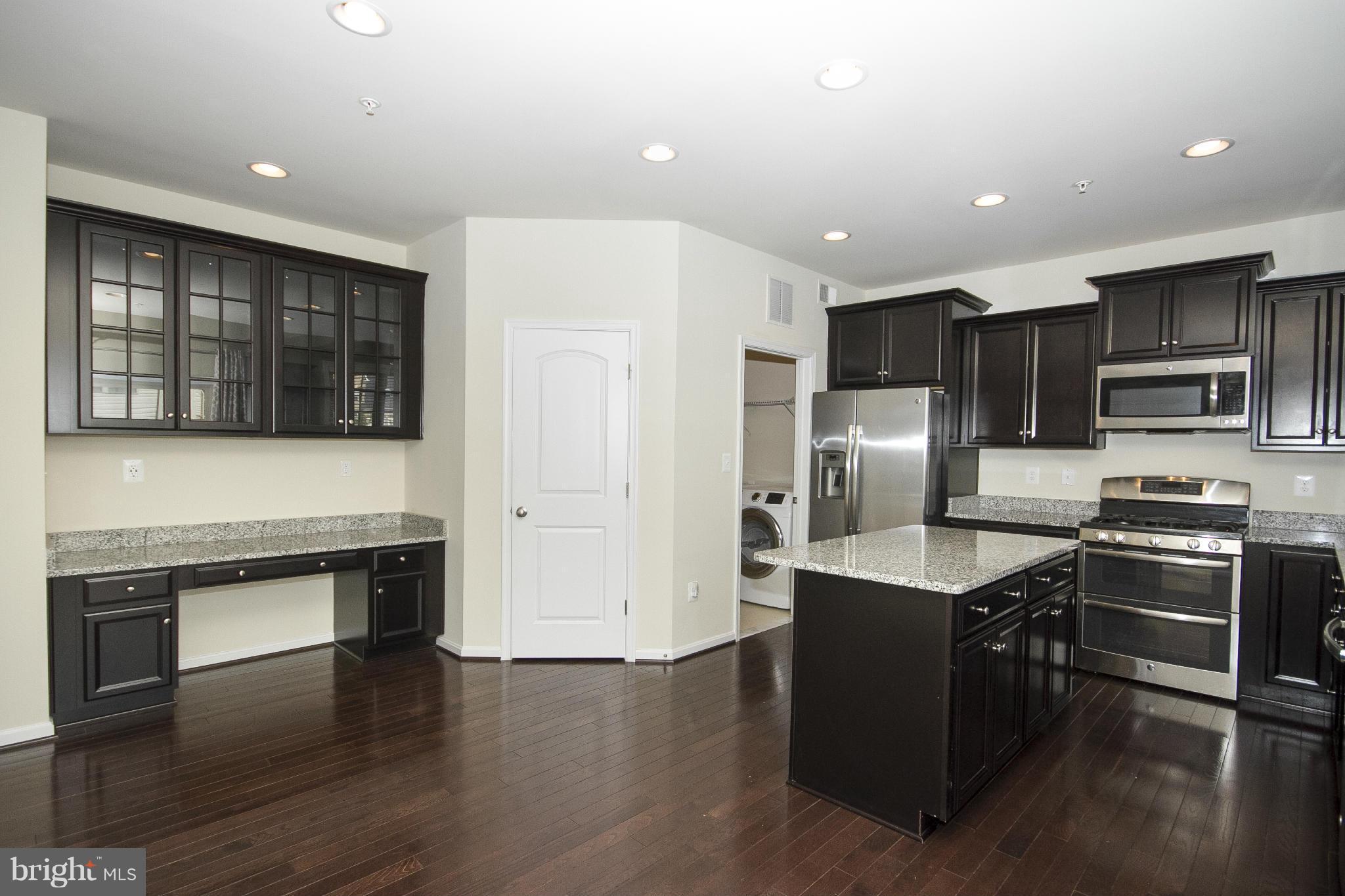 4310 Stoss Road Perry Hall, MD 21128 - Photo 11 of 22 a kitchen with stainless steel appliances granite countertop a refrigerator a stove top oven a sink and dishwasher with wooden floor