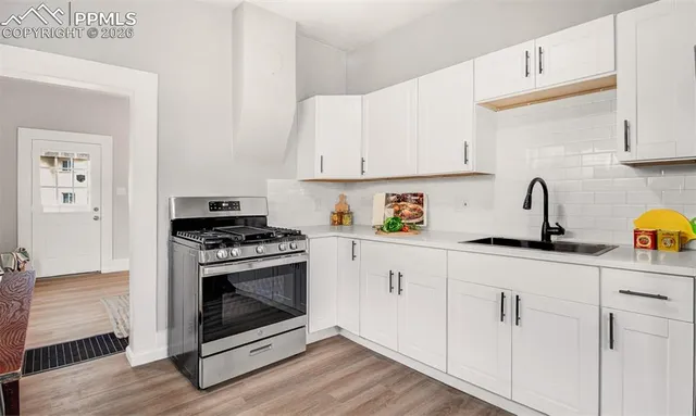 a kitchen with white cabinets and appliances