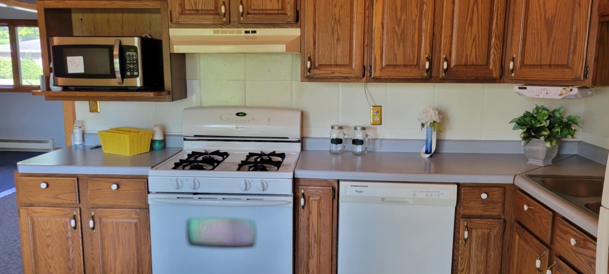 451 Rebecca Road Belvidere, IL 61008 - Photo 11 of 30 a kitchen with a stove and a white cabinets