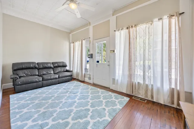 a living room with furniture and a wooden floor