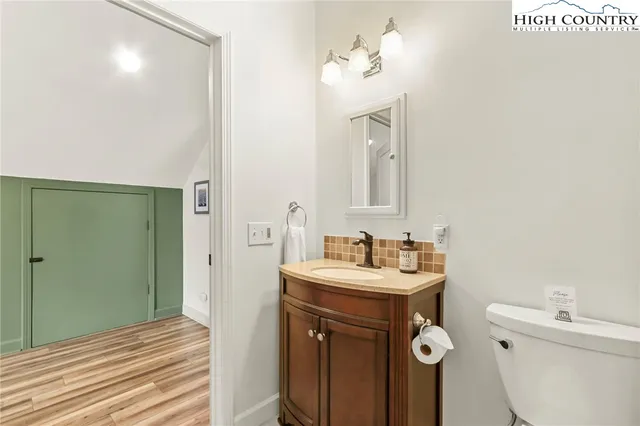a view of a room with wooden floor and a ceiling fan
