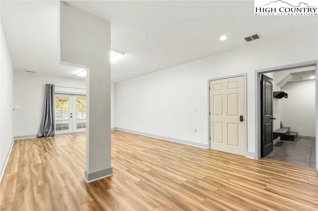 a living room with furniture floor to ceiling window and a flat screen tv