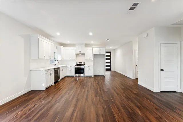 a kitchen with wooden floors and white appliances