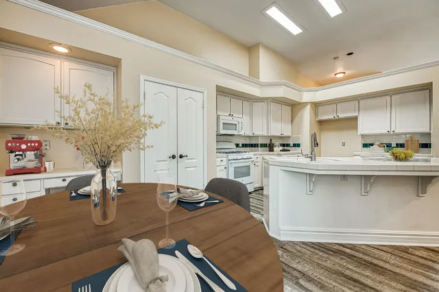 a kitchen with a table chairs refrigerator and microwave