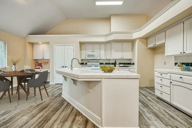 a kitchen with granite countertop a sink appliances cabinets and furniture
