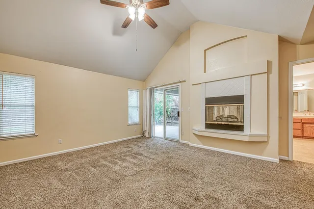 a spacious bathroom with a granite countertop double vanity sink a mirror and a bathtub