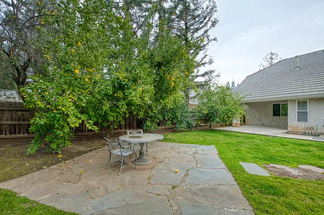 a front view of a house with a garden and trees