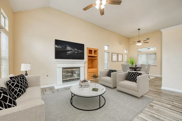a living room with furniture a fireplace and a flat screen tv