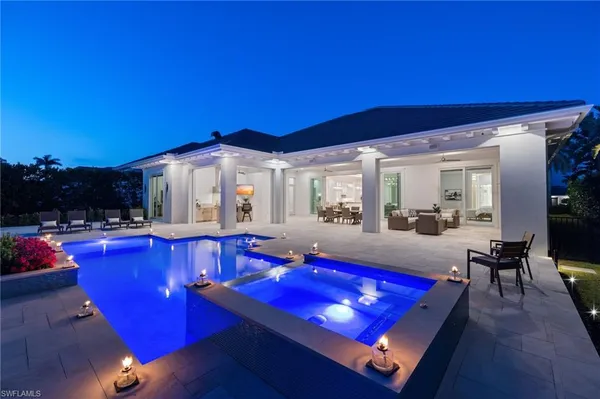 a living room with furniture a flat screen tv and a dining table with kitchen view