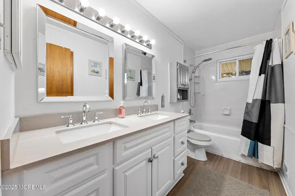 a bathroom with a double vanity sink toilet and a mirror
