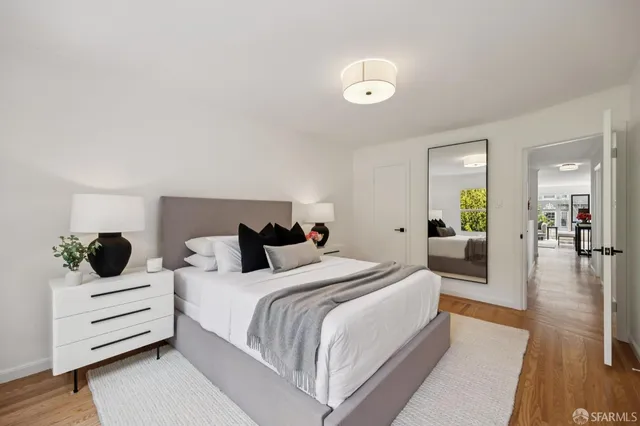 a bedroom with a bed and wooden floor