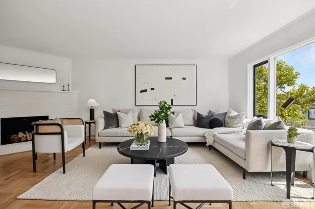 a living room with furniture potted plant and a large window