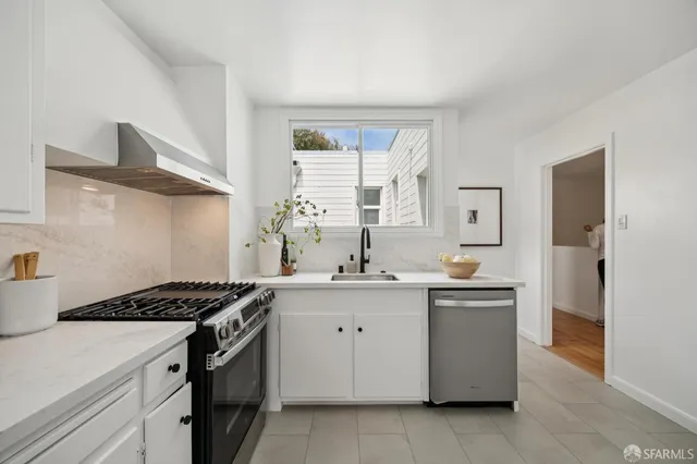 a kitchen with stainless steel appliances a sink stove and cabinets