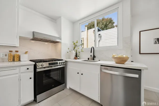 a kitchen with stainless steel appliances a stove sink and cabinets