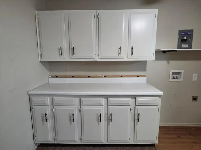 a kitchen with a sink a stove cabinets and wooden floor