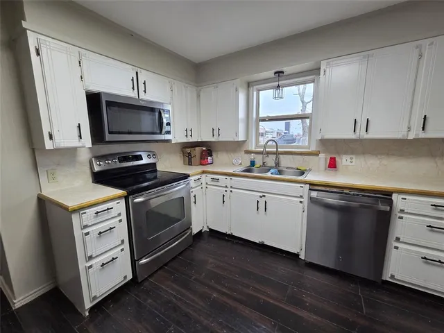 a kitchen with a sink stainless steel appliances and cabinets