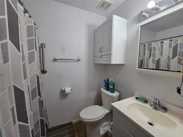 a bathroom with a sink toilet and a mirror