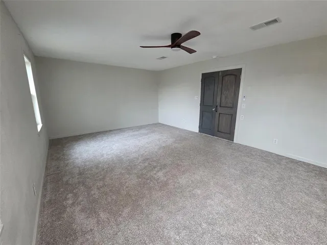 a view of a livingroom with a ceiling fan and window
