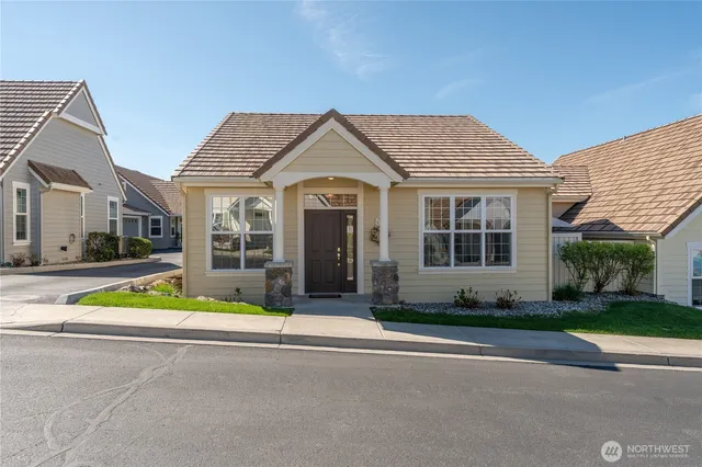 a front view of a house with a yard and potted plants