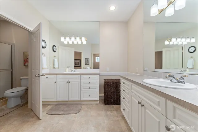 a spacious bathroom with a granite countertop sink a toilet and a mirror