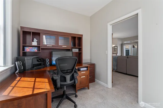 a view of a workspace with furniture and a window