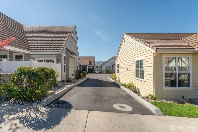 a view of a street with a house in the background