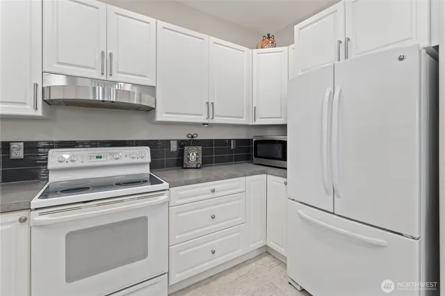 a kitchen with white cabinets and white appliances