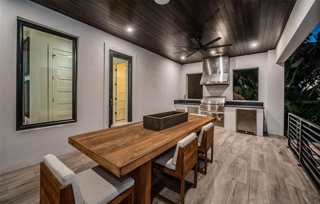 218 Sydney Lane Redington Shores, FL 33708 - Photo 20 of 100 a kitchen with stainless steel appliances granite countertop a stove a refrigerator a microwave oven with a dining table and chairs with wooden floor