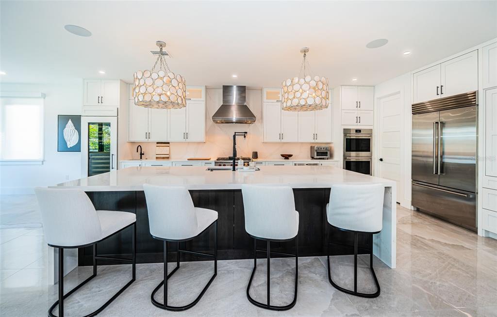 218 Sydney Lane Redington Shores, FL 33708 - Photo 29 of 100 a kitchen with stainless steel appliances kitchen island granite countertop a dining table chairs and a refrigerator