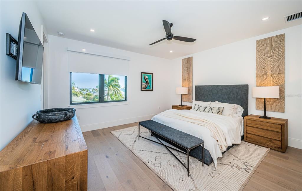 218 Sydney Lane Redington Shores, FL 33708 - Photo 74 of 100 a bedroom with a bed and a flat tv screen on the dresser