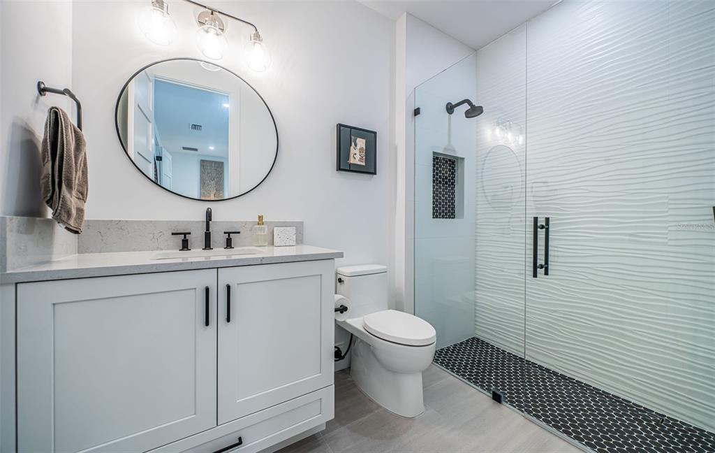218 Sydney Lane Redington Shores, FL 33708 - Photo 76 of 100 a bathroom with a toilet a sink a mirror and vanity