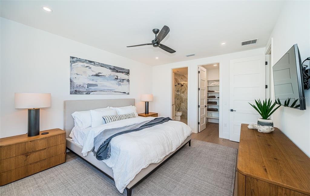 218 Sydney Lane Redington Shores, FL 33708 - Photo 78 of 100 a spacious bedroom with a bed and a lamp