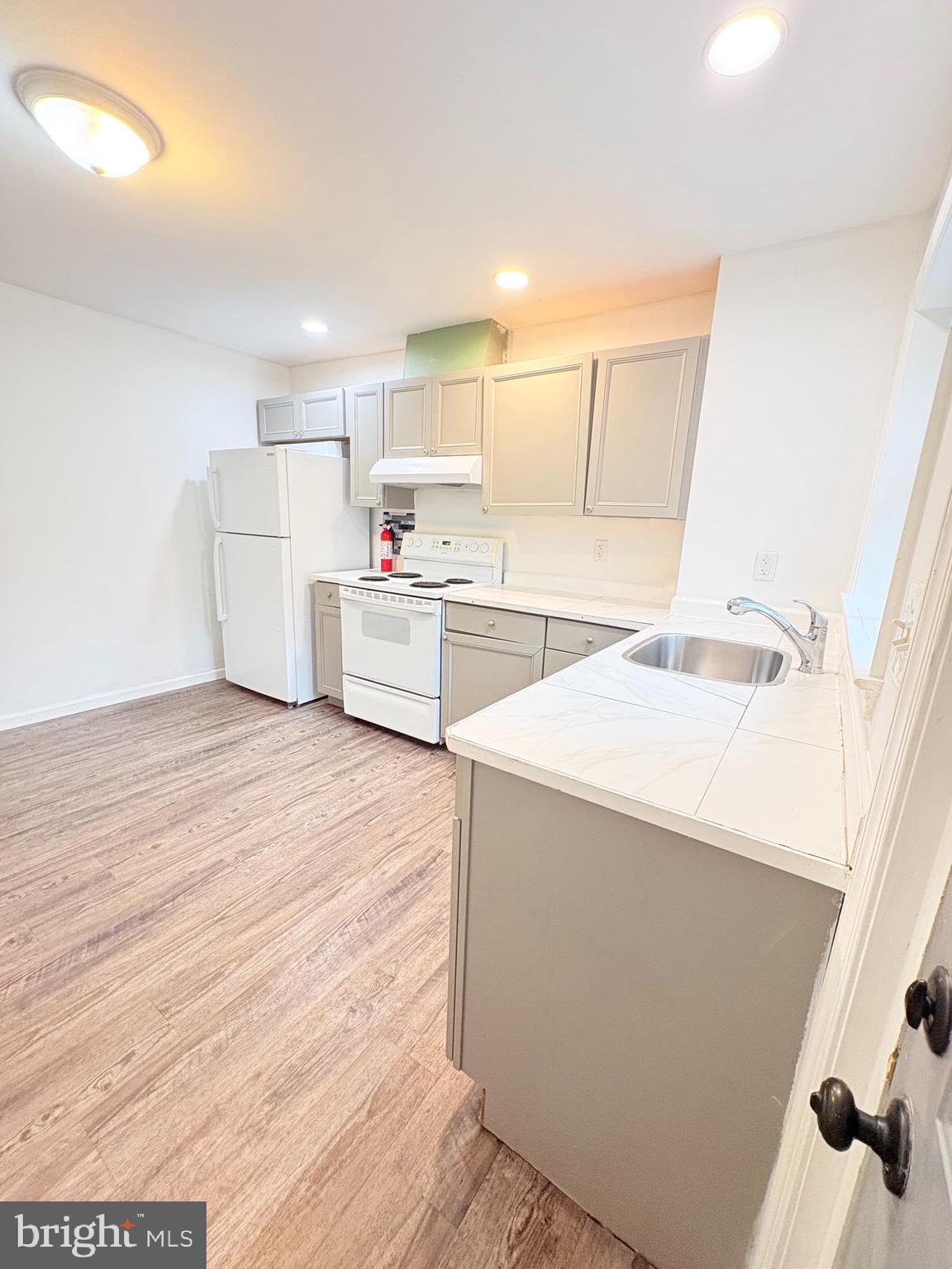 1630 East 9th Street Bethlehem, PA 18015 - Photo 9 of 17 a kitchen with a sink a stove cabinets and wooden floor