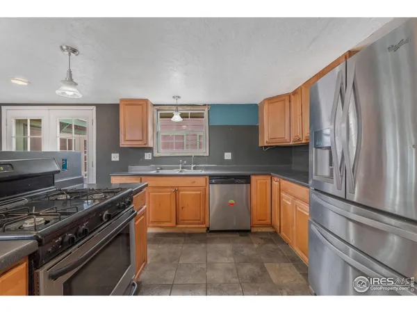 a kitchen with stainless steel appliances granite countertop a stove a sink and a refrigerator