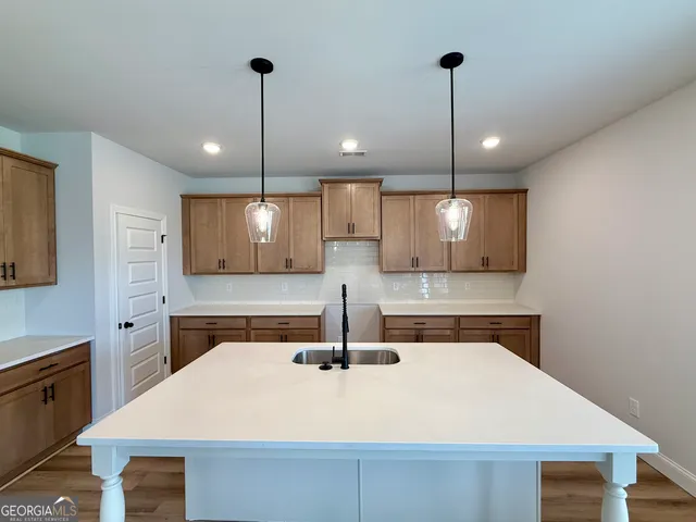 a kitchen with stainless steel appliances granite countertop a sink a stove and cabinets