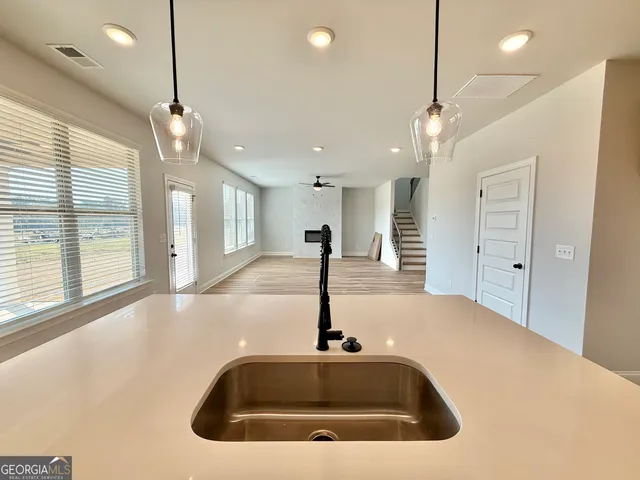 a large kitchen with stainless steel appliances kitchen island a large counter top a sink a stove and a refrigerator