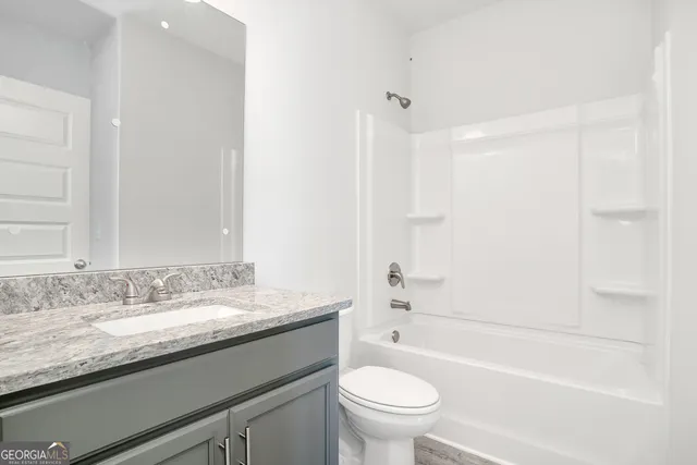 a view of a hallway with wooden floor and entryway