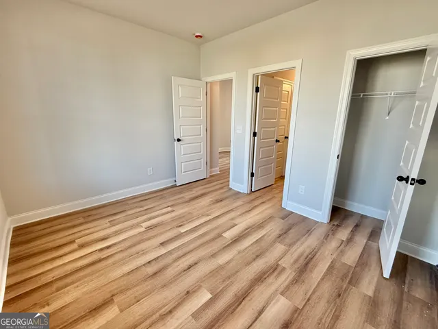 a view of a room with wooden floor and door