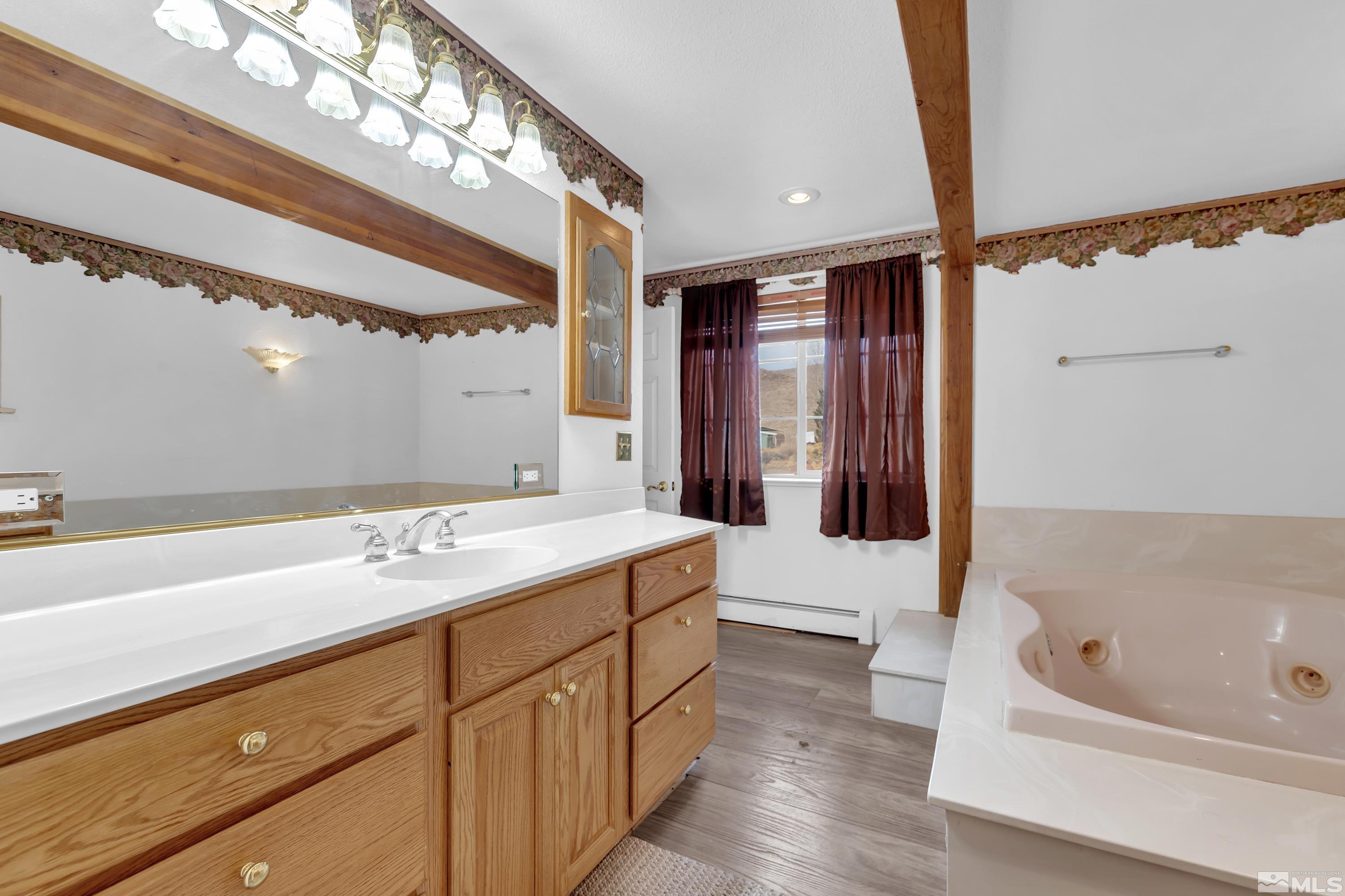 333 Territory Road Dayton, NV 89403 - Photo 22 of 38 a bathroom with a tub a double vanity sink and mirror