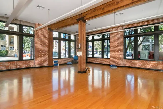 a view of empty room with wooden floor and windows
