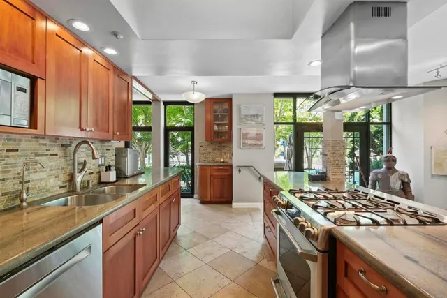 a kitchen with a stove a sink a refrigerator and wooden cabinets