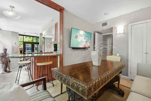 a living room with dining table a rug and kitchen view
