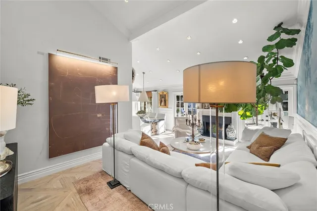 a living room with furniture and potted plant with wooden floor