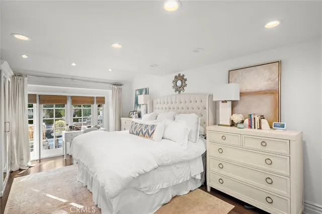 a large white bedroom with a bed and dresser