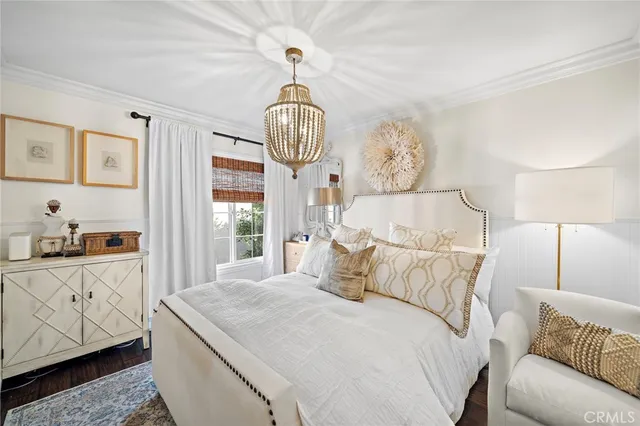 a bedroom with a large bed and a chandelier