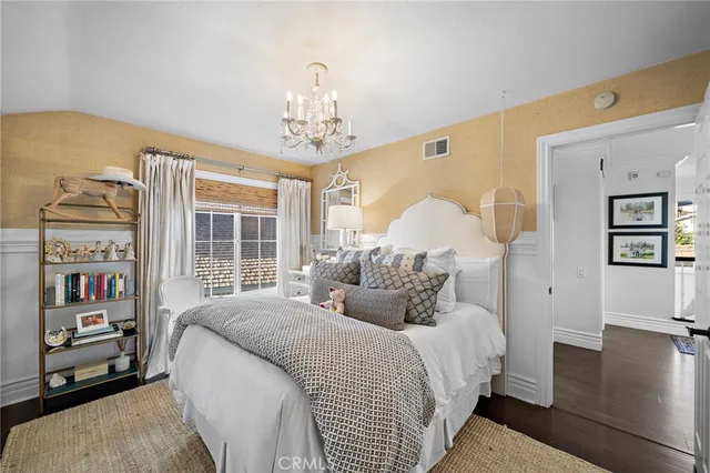 a bedroom with a large bed and a chandelier