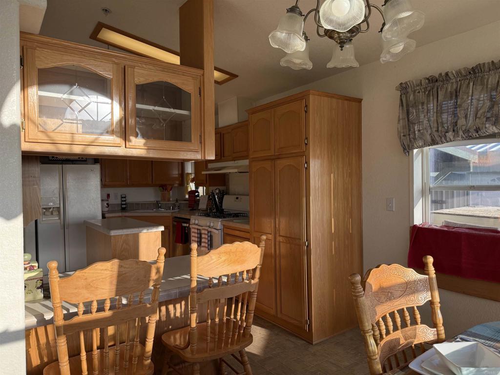 37697 Montezuma Valley Road Ranchita, CA 92066 - Photo 15 of 47 a kitchen with stainless steel appliances kitchen island granite countertop a table chairs in it and wooden floor