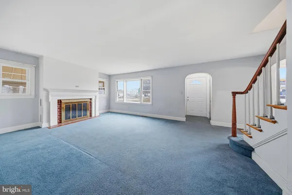 a view of an empty room with fireplace and a window