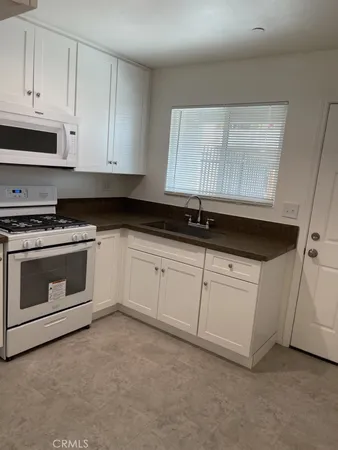a kitchen with white cabinets and white appliances